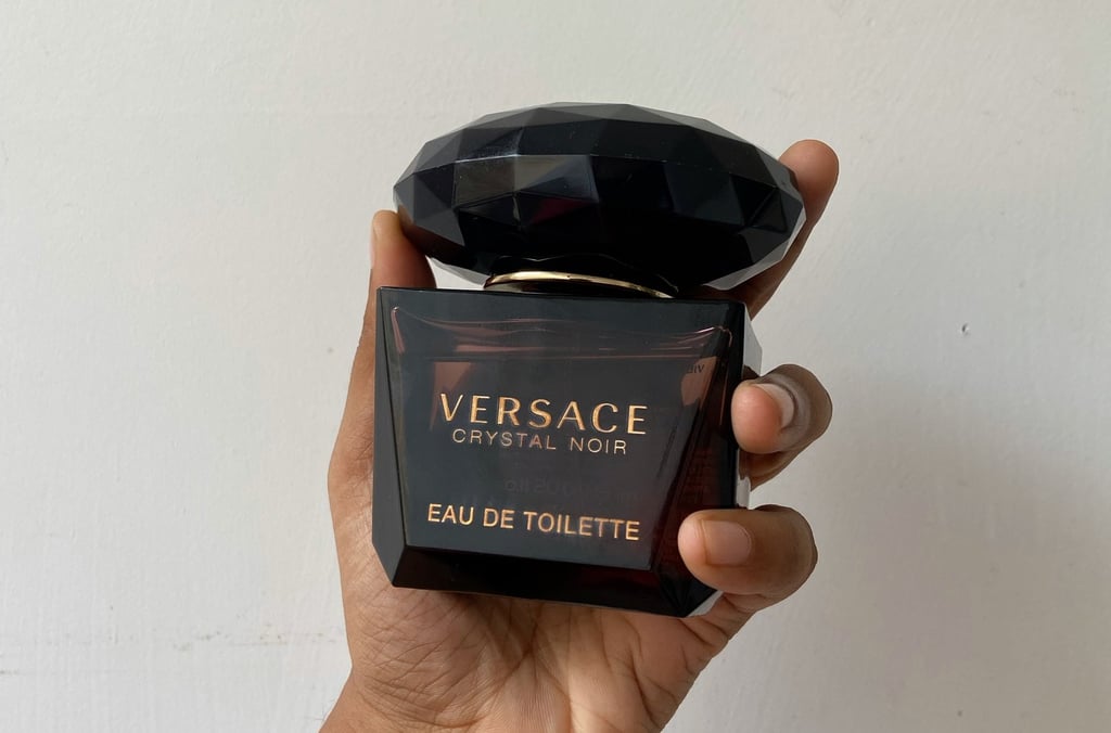 A person holding versace crystal noir