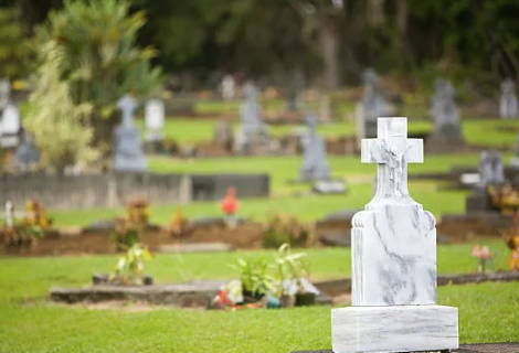 a cross - cut stone memorial cross in a cemetery