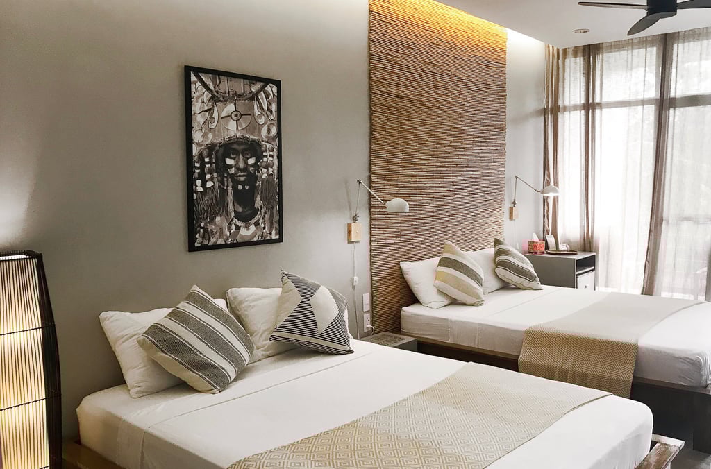 a bedroom with two beds and a ceiling fan