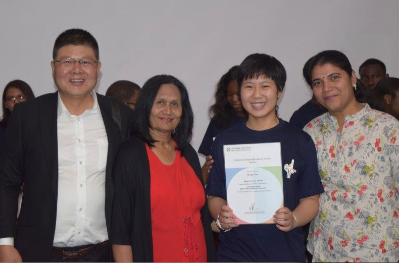 a group of people standing around a man holding a certificate
