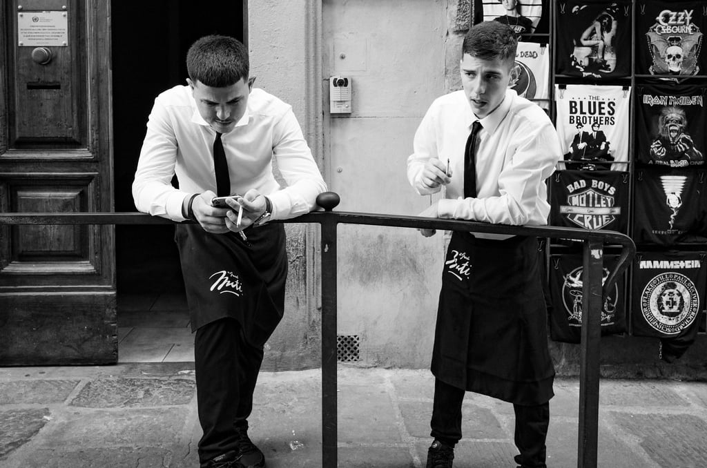 Two Italian waiters taking a cigarette break on a street in Florence