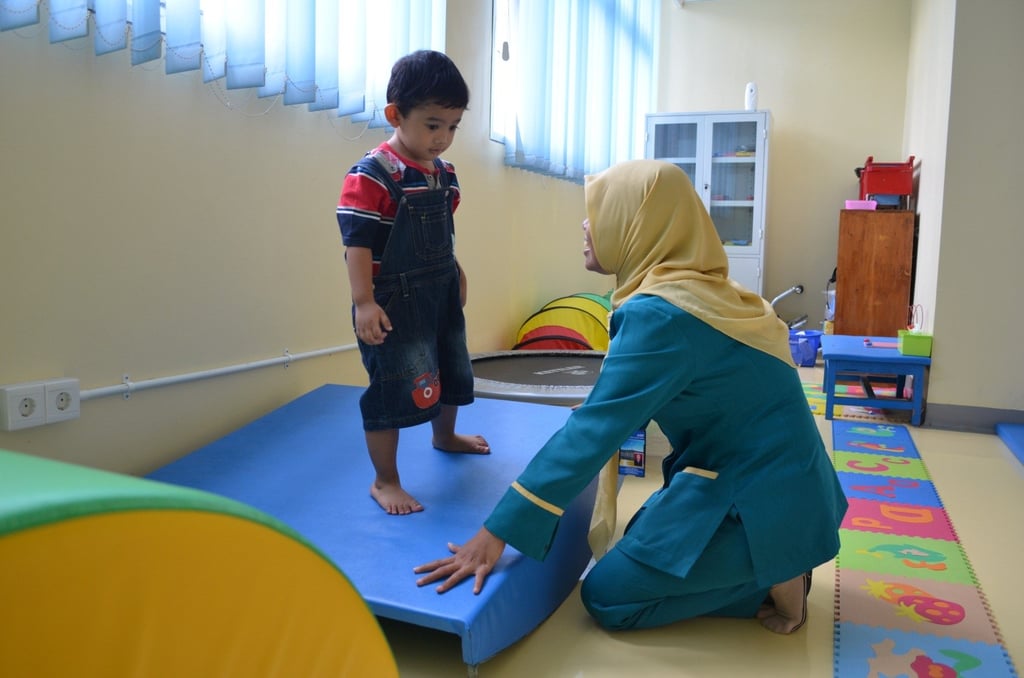seorang anak yang sedang diterapi okupasi menggunakan alat terapi vestibular