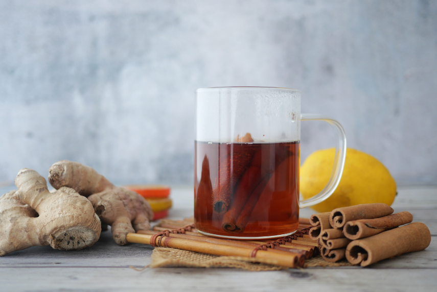 Ginger tea in a glass mug with cinnamon sticks