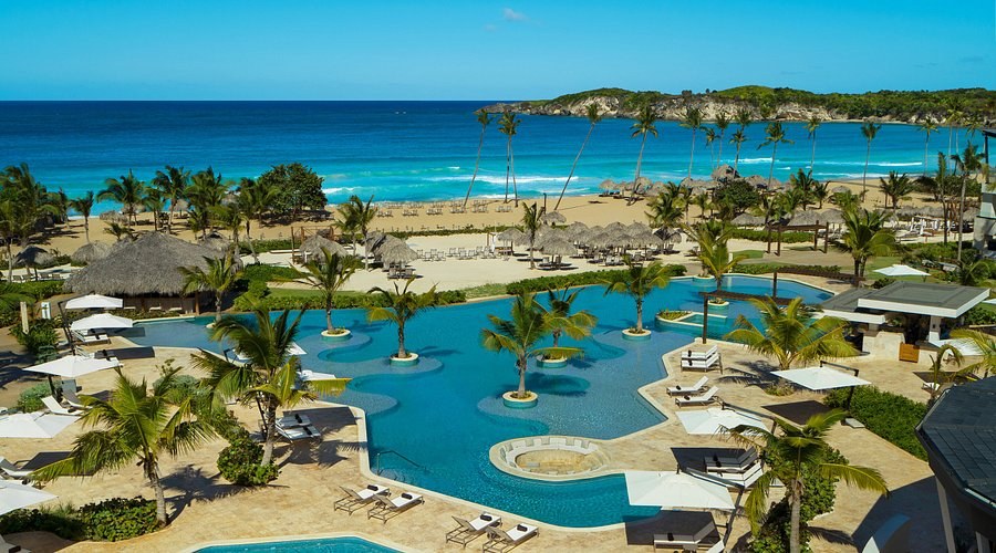 Aerial view of Playa Macao with palm trees, golden sand, and turquoise Atlantic water in Punta Cana