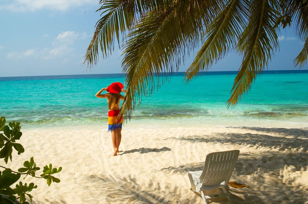 a woman with a red hat on a beach in the dominican republic