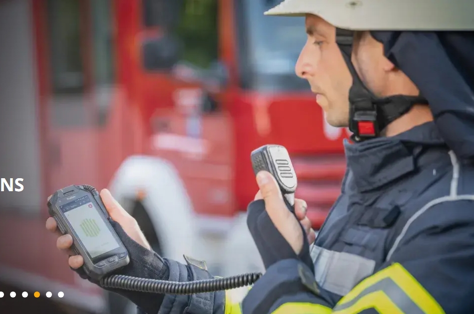 Firefighter using microphone/speaker connected to his PoC radio