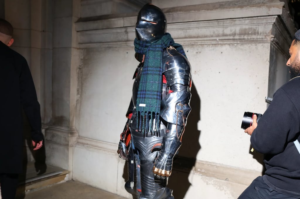 Guest in full armour with scarf at London Fashion Week 2026.