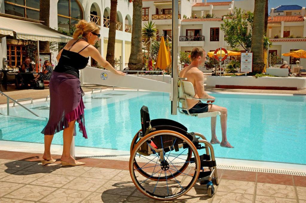 woman in wheelchair using a handicap lift at the swimming pool