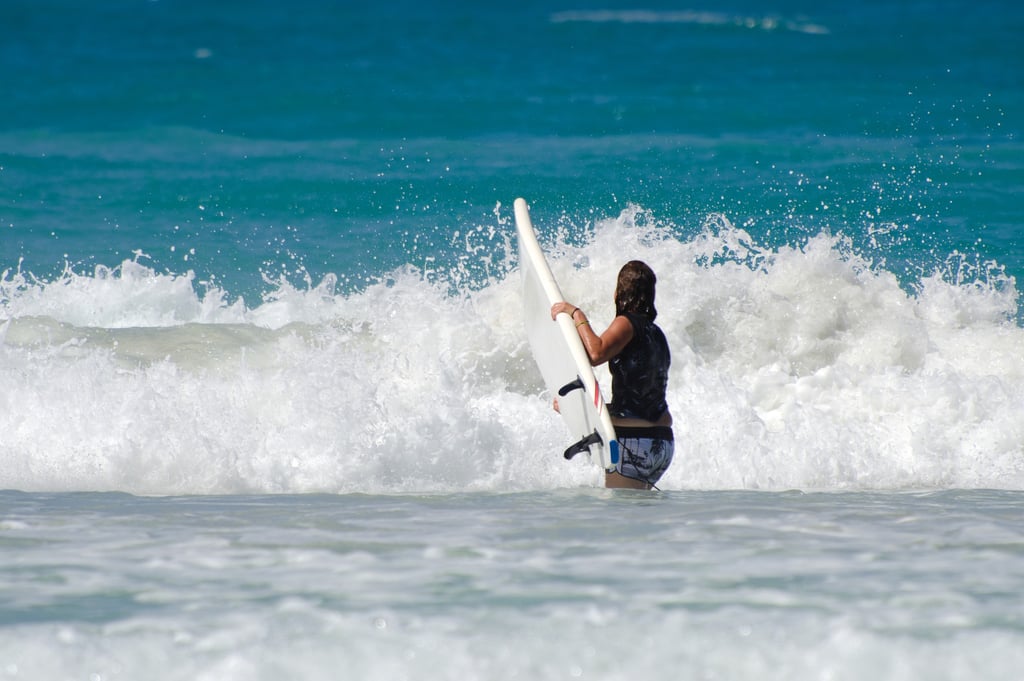 Surfer with board facing ocean waves at Macao Beach Punta Cana Dominican Republic
