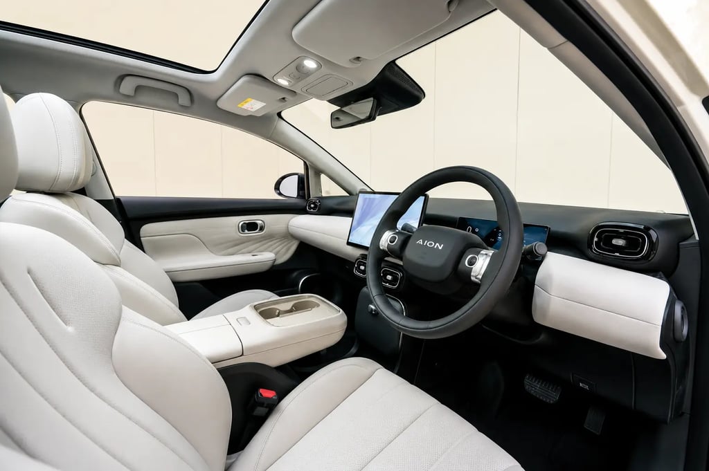 Interior do GAC Aion UT com bancos claros, teto panorâmico e painel multimídia moderno