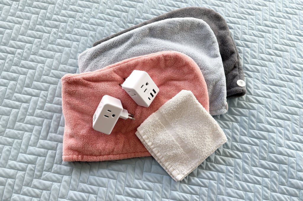 Microfiber hair towels in three colors with two travel adapters and a white washcloth for hotel use