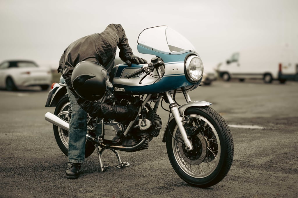 motard démarrant une ancienne ducati 900 ss sur un parking