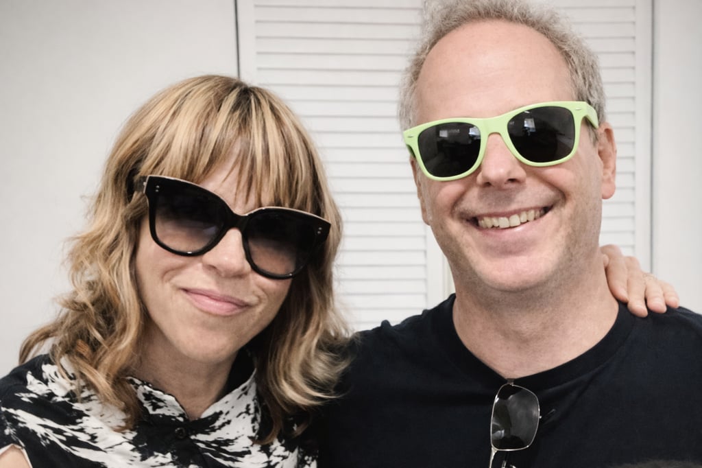 Tracy and Dan wearing stylish sunglasses and casual attire standing together.