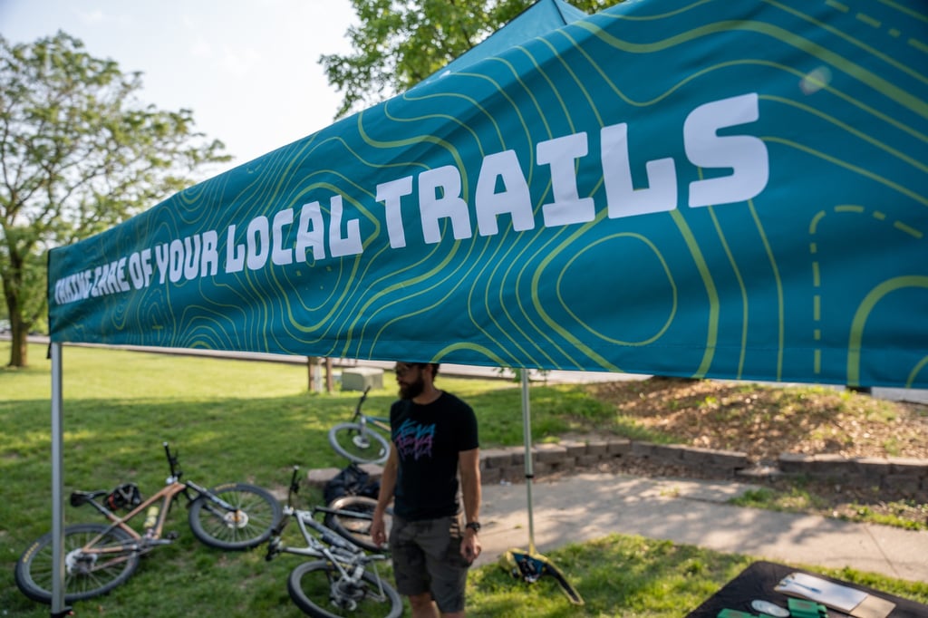 Someone standing under the COMOTA tent with bikes laying on the ground