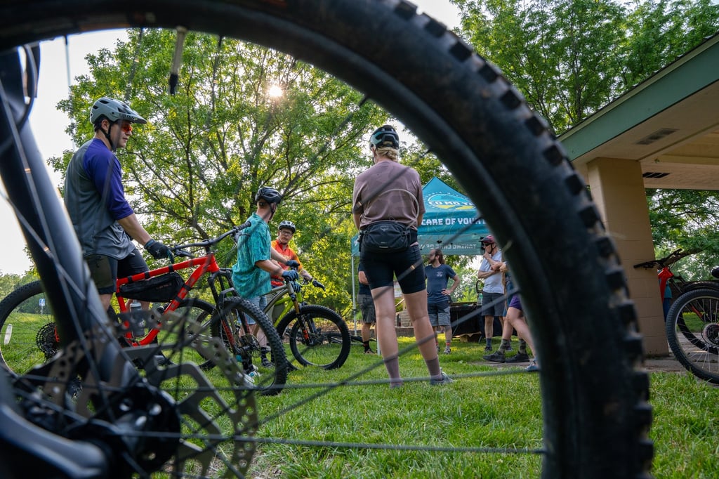 People on bikes in the background of a photo with the focus on a bike tire