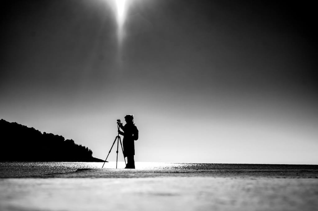 Tina Bikic holding a camera, black and white artistic portrait.