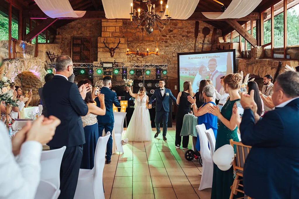 Mariés qui entrent en dansant dans la salle de réception de mariage de l'Auberge de la Klauss.
