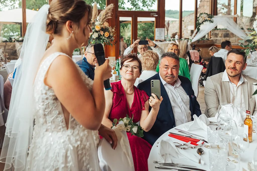 Famille qui écoute attentivement leur fille mariée qui fait un discours.
