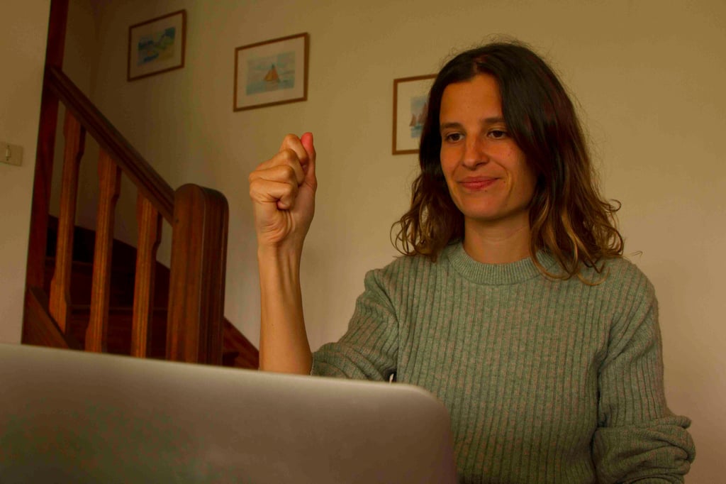 Laura Capit sitting at a table with a laptop computer
