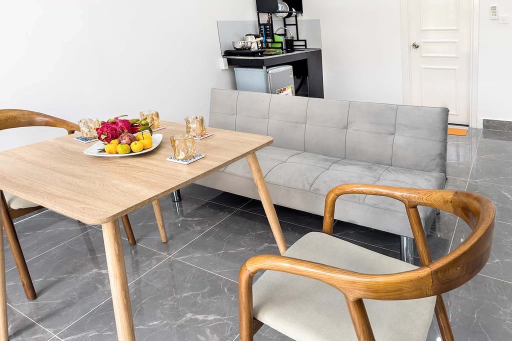 Столовая зона с фруктами и уютным диваном в светлом интерьере