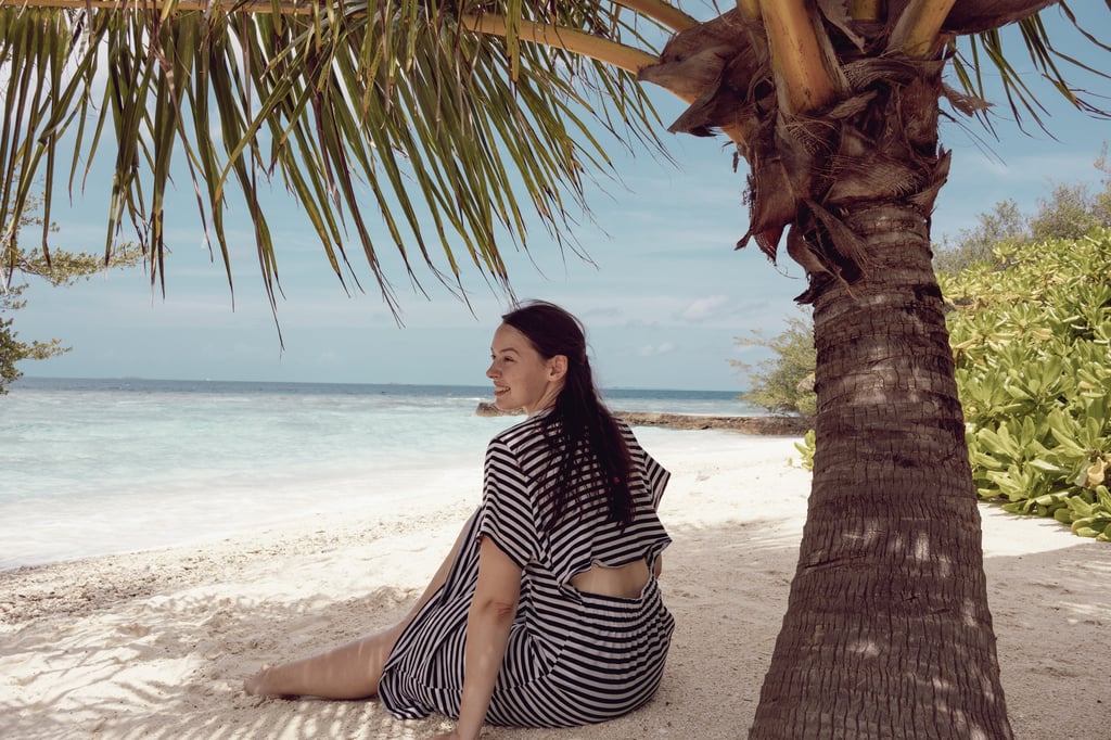 Reisefotografie Malediven: Jana von Lebensmomente fotografiertgenießt einen Moment am Strand.