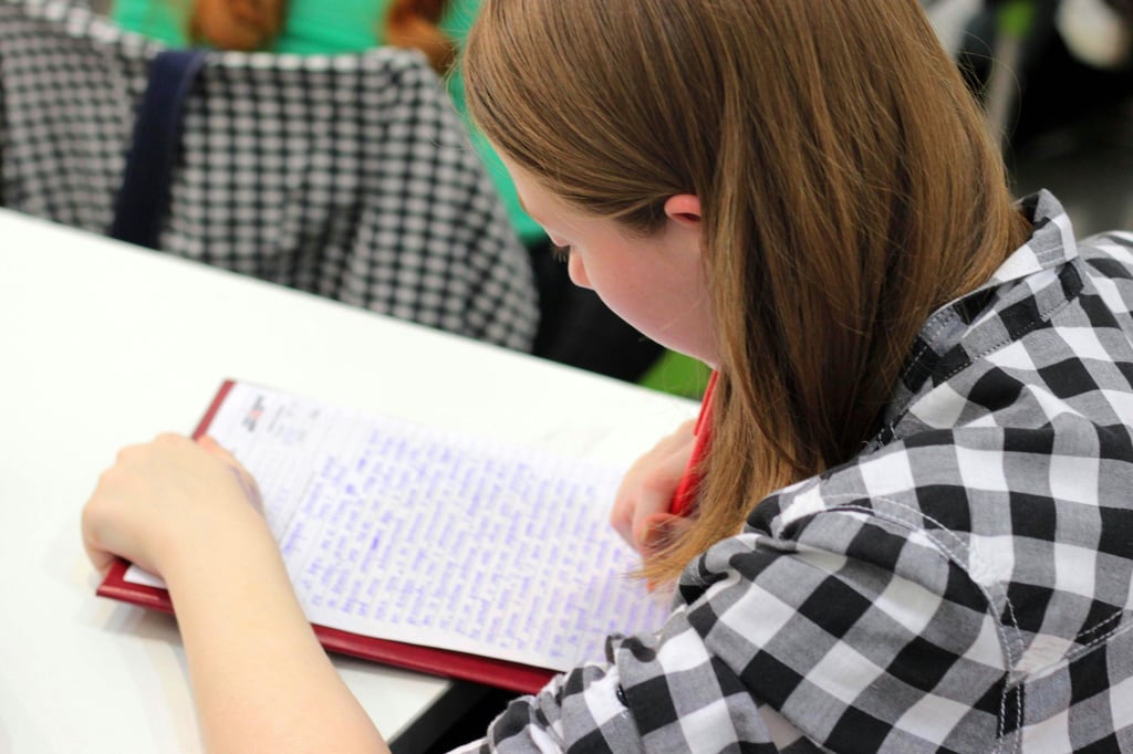 a gifted girl is writing on a notebook
