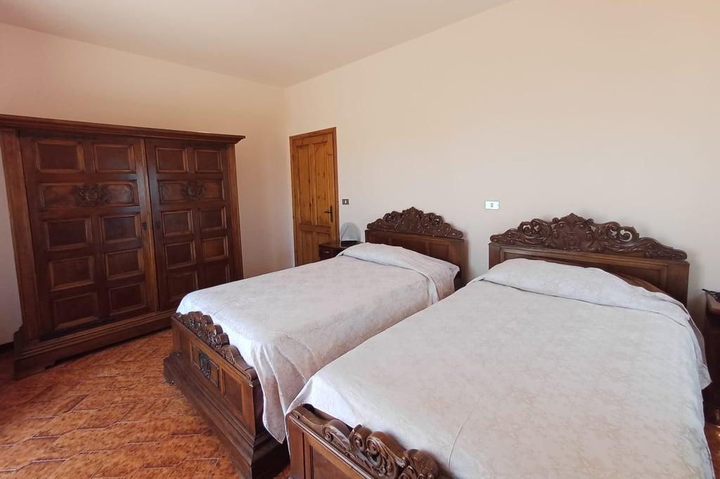 Camera matrimoniale del B&B con arredi classici in legno scuro e atmosfera accogliente.