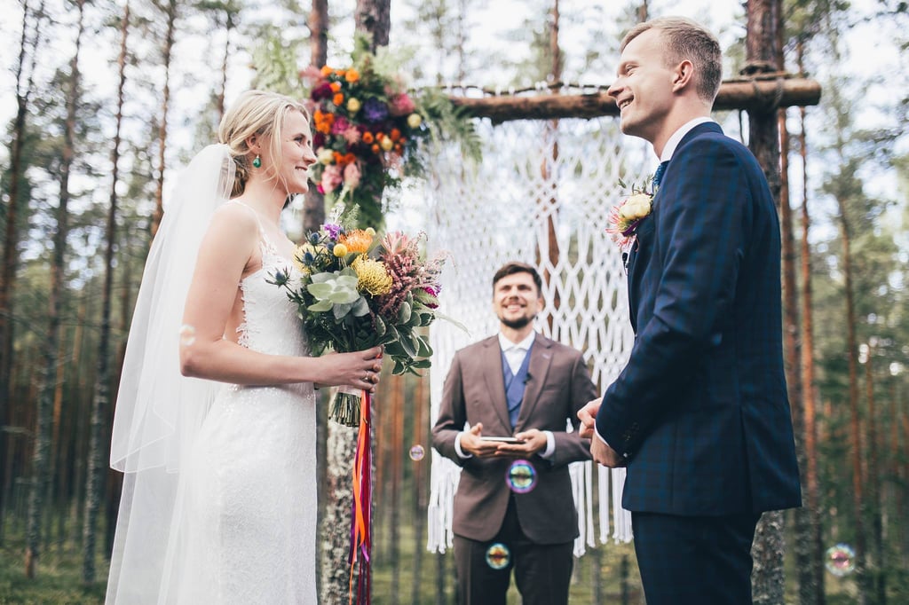 a bride and groom are getting married in a forest
