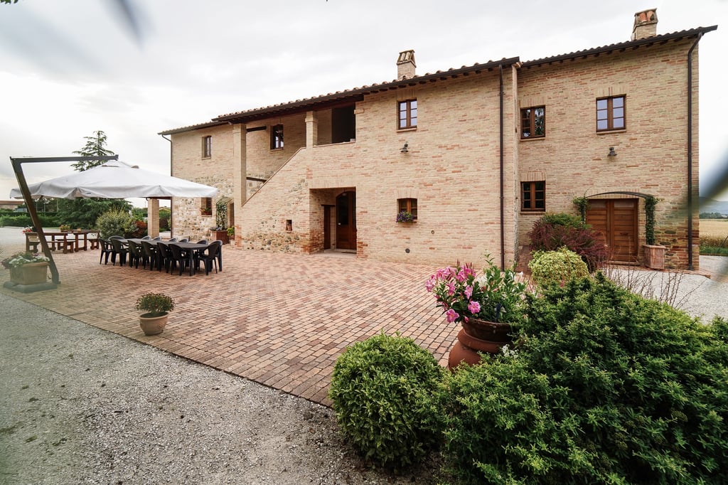 Veduta esterna del casale e giardino in una giornata nuvolosa