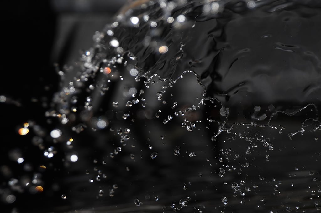 a close up of a water fountain with water droplets