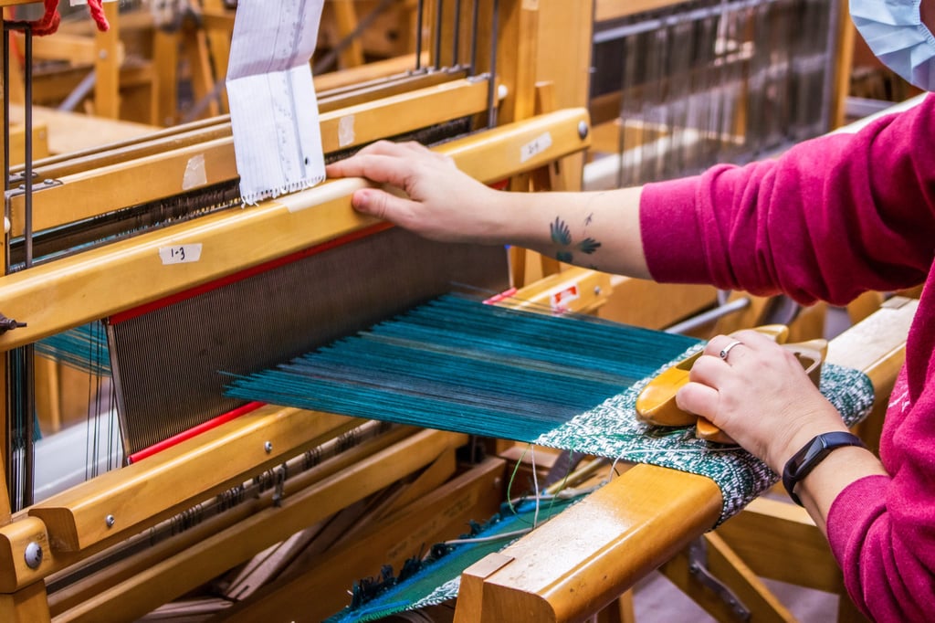 Student using a floor loom in one of our weaving classes.