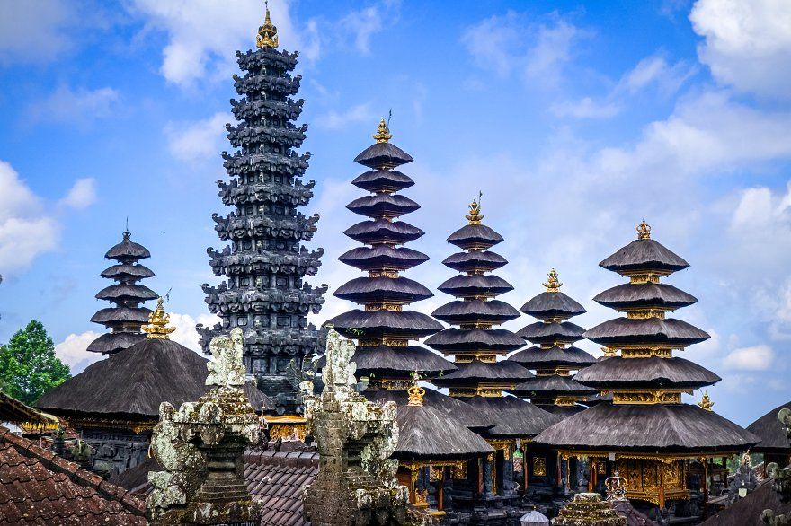 Besakih Temple gates made of black volcanic stone against a clear blue sky