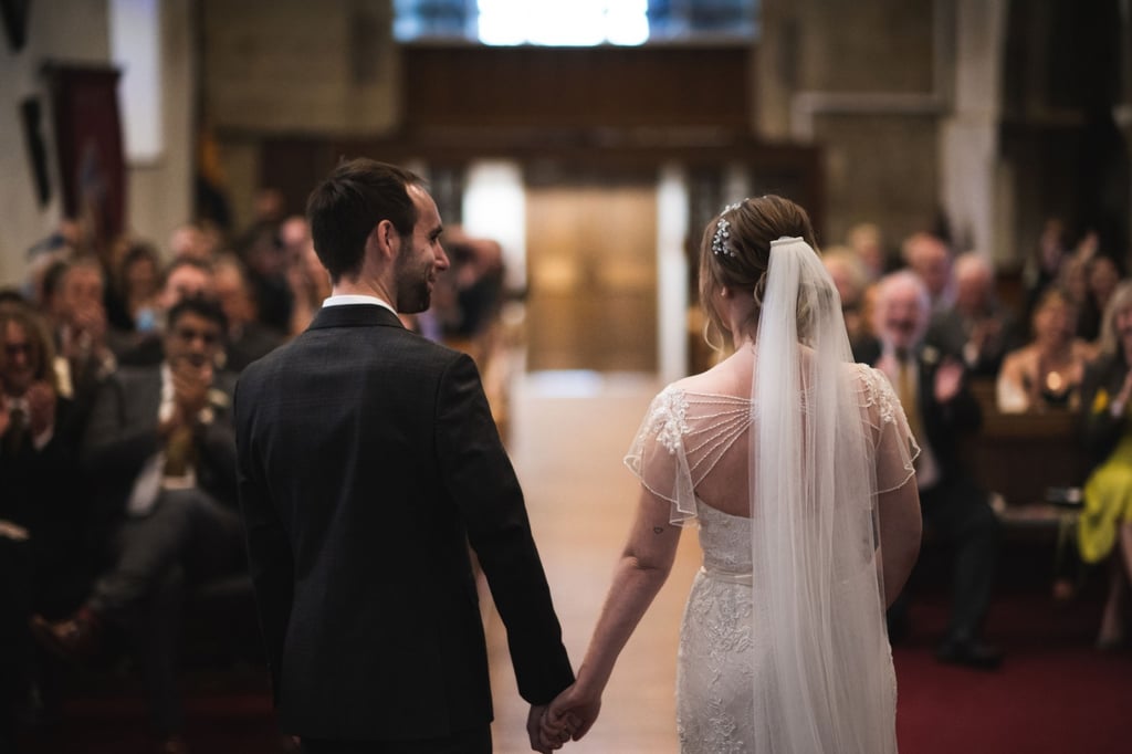 a bride and groom holding hands in a church