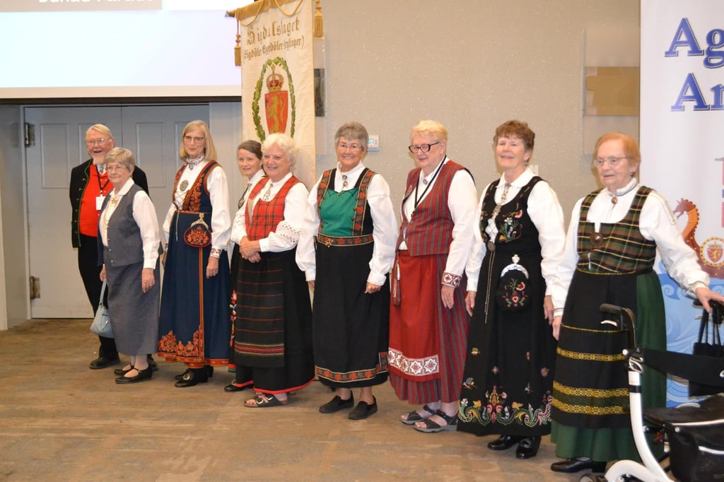 one man and eight women in bunad