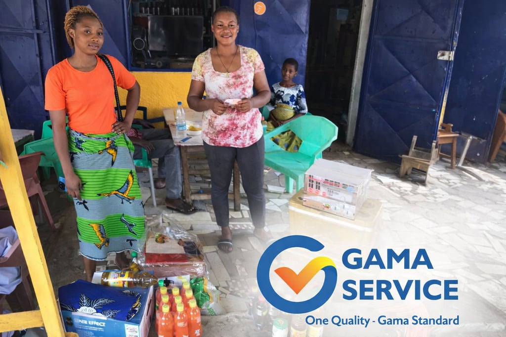 African women smiling outside a local storefront with groceries and Gama Service branding.