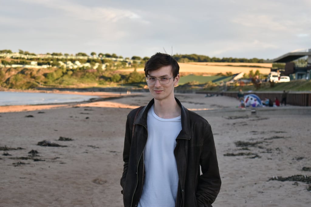 a man standing on a beach with a surfboard