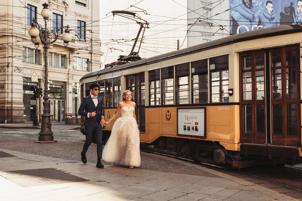 a bride and groom walking down the street in Milan