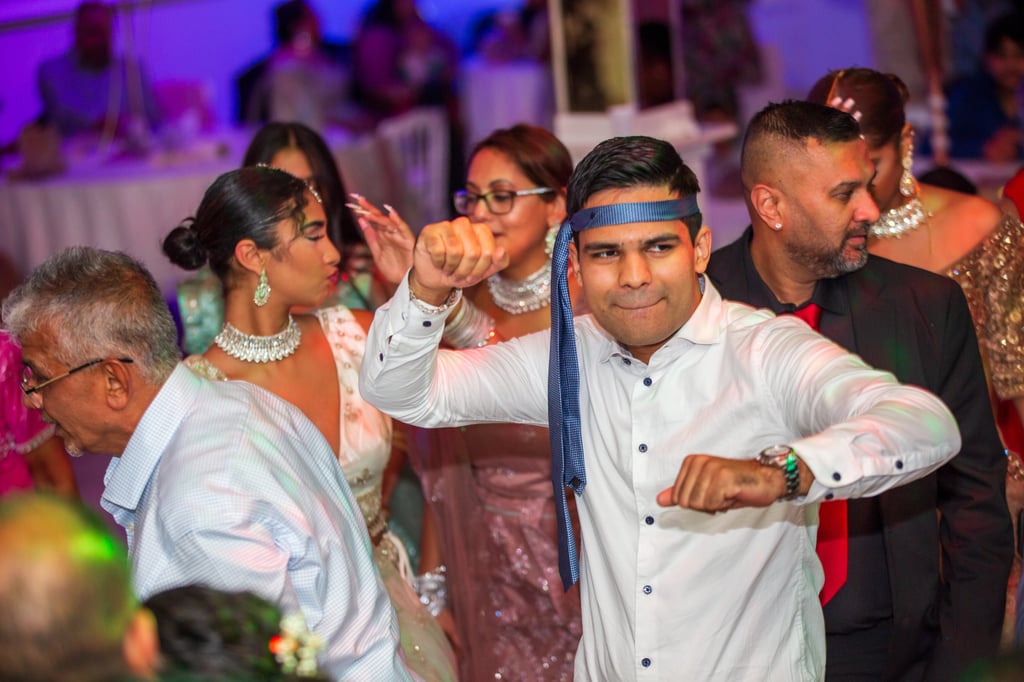 man aan het dansen met een stropdas om het hoofd