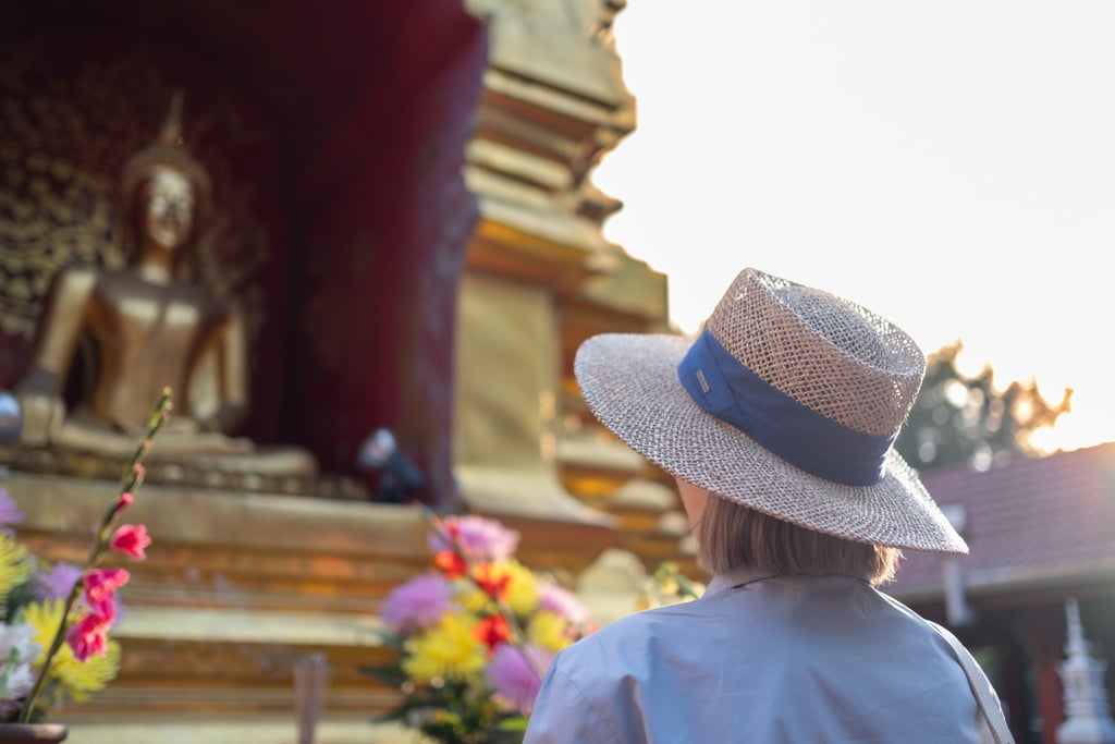 Solo female traveler meditating in Chiang Mai temple