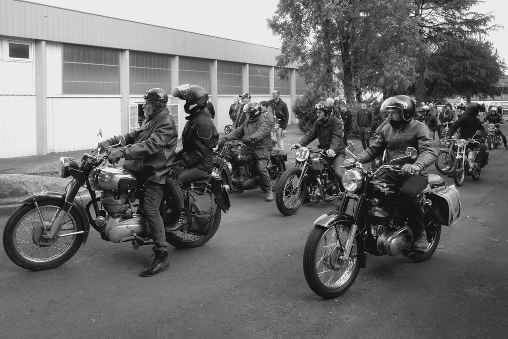 a group of people riding motorcycles down a street
