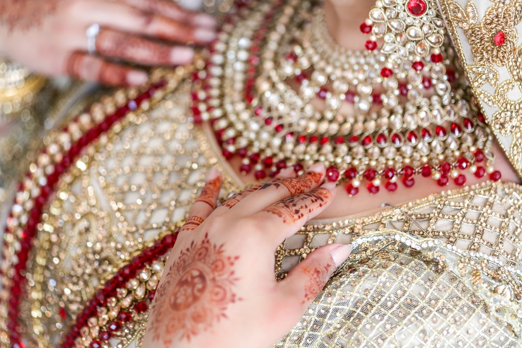 close up photo of asian bride's traditional gold dress and traditional jewellery 