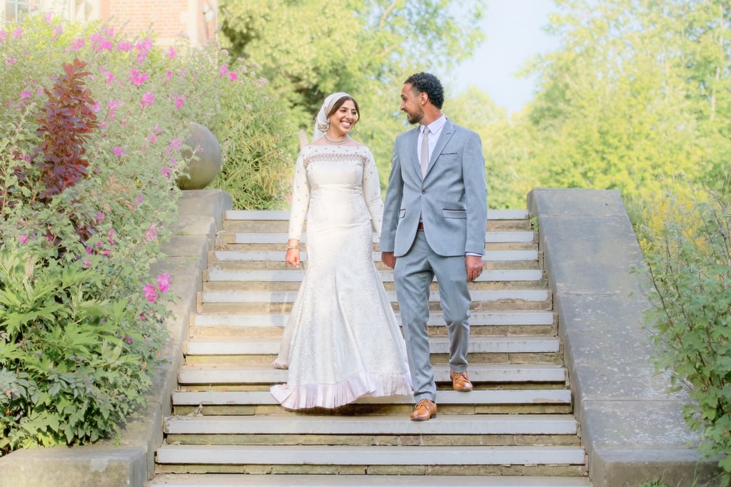bride and groom walking down step in Stanley home garden, light and airy photo surrounded by flowers 