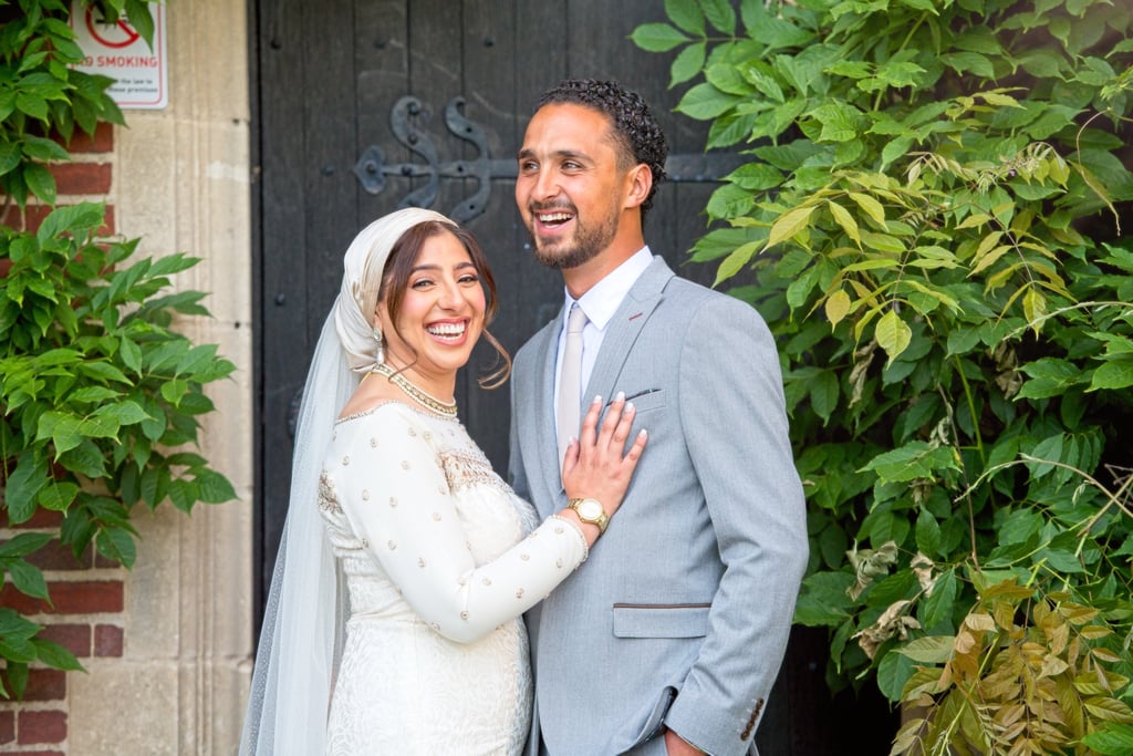 bride and groom in front of stately home being candid laughing and smiling 