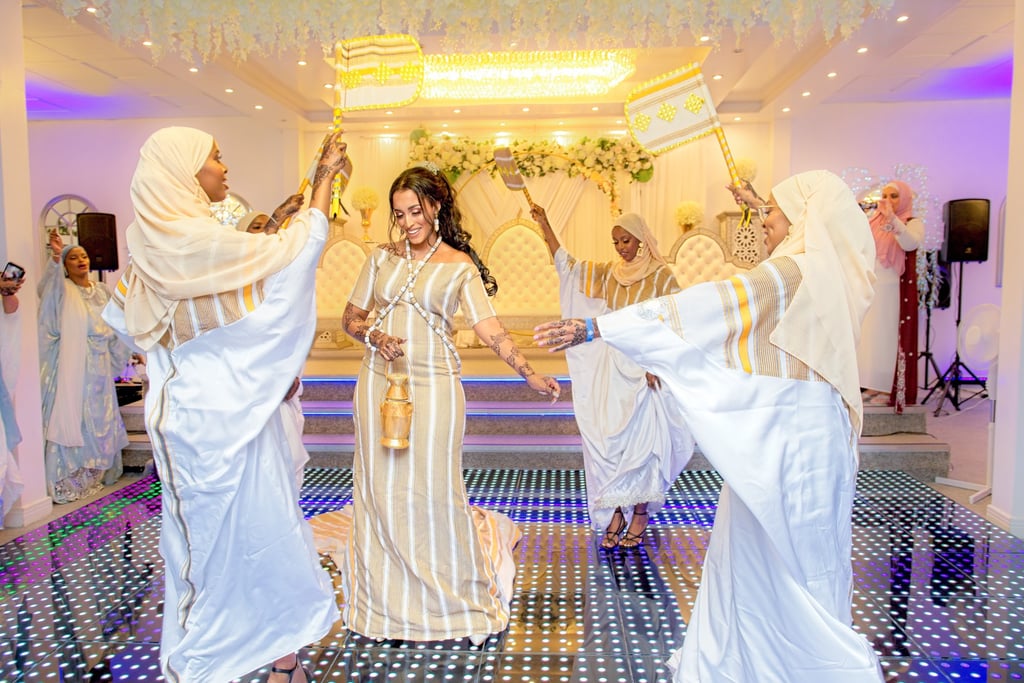 Somalian bride dancing in centre, bridesmaids in a circle around bride all happy and having a good time