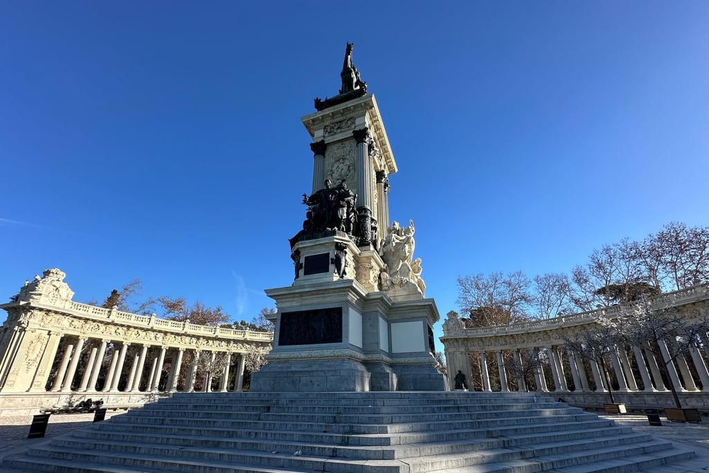 A statue of a man, horseback and on a pedestal surrounded by a portcullis