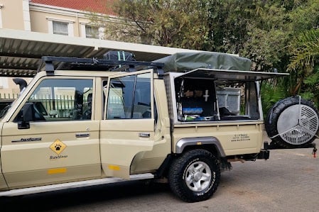 a vehicle parked in a parking lot with a tenter and a tent