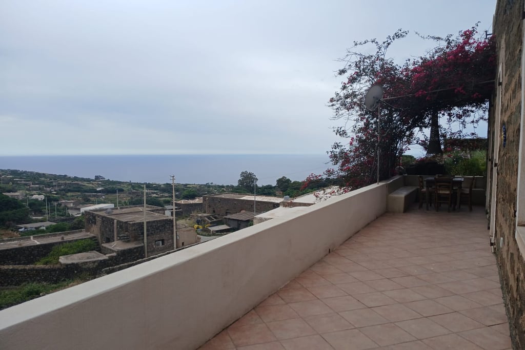 Panoramic terrace of dammuso in Rekhale with flowering pergola and sea view