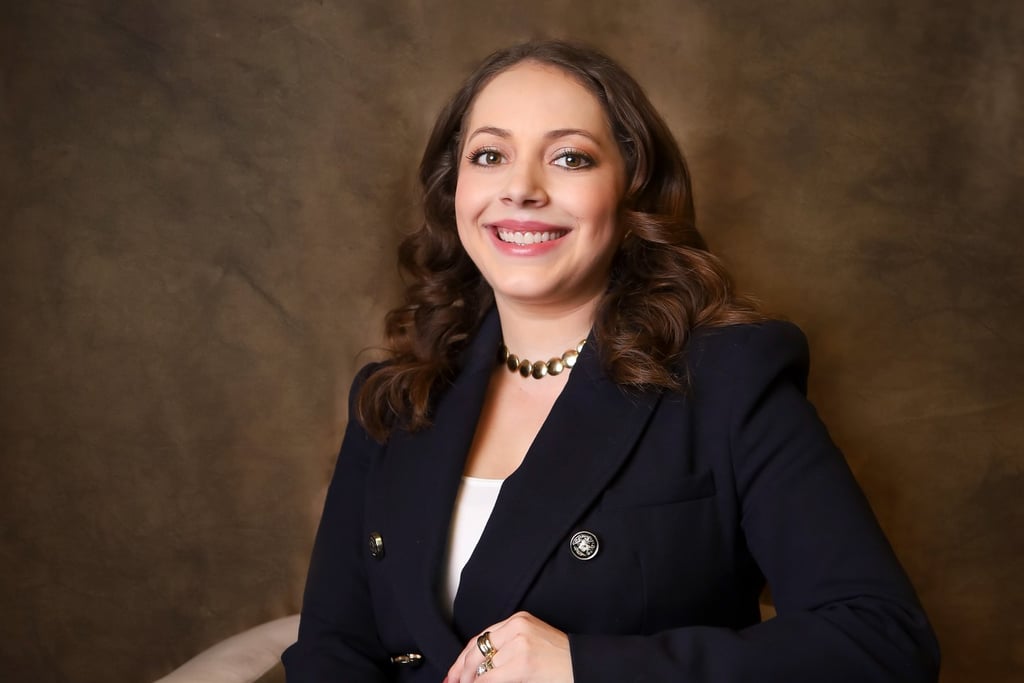 a woman in a suit and a necklace