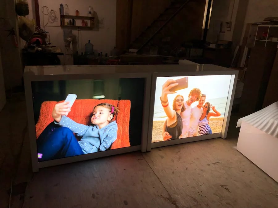 Backlit fabric light box displays featuring high-resolution lifestyle graphics in a warehouse setting.