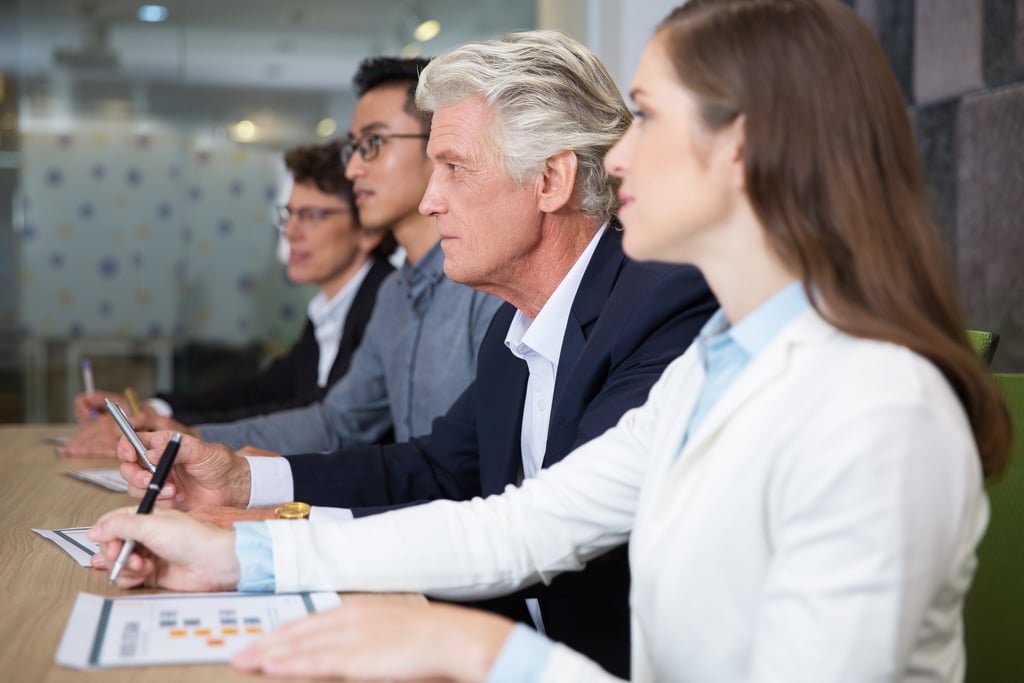 Equipo directivo sentado frente a mesa